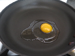 raw egg in frying pan